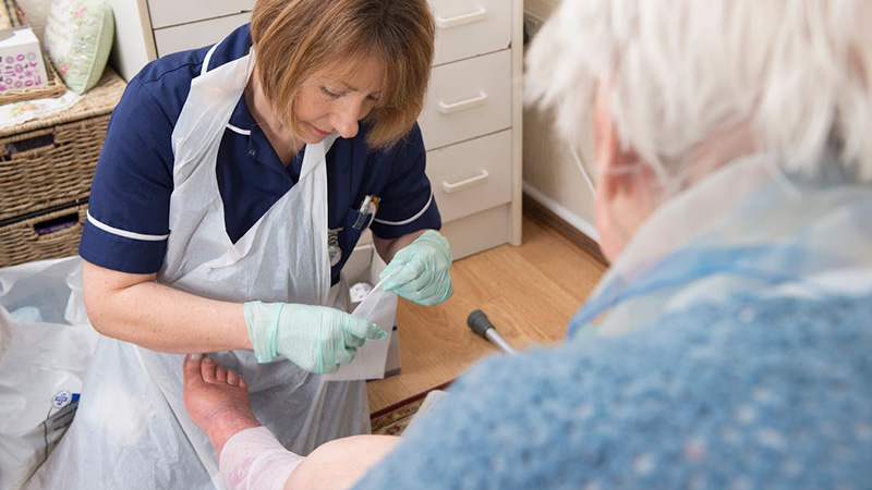 District Nursing student providing care to elderly patient on placement at Oxford Brookes University
