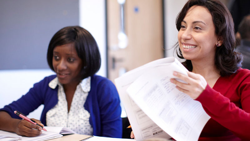 Two women looking at notes