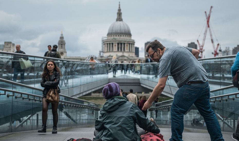 person donating money to beggar
