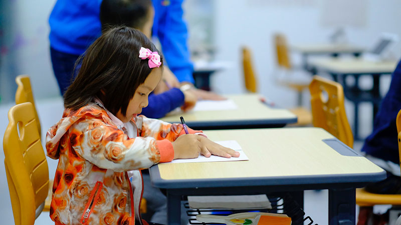 Girl writing at school desk