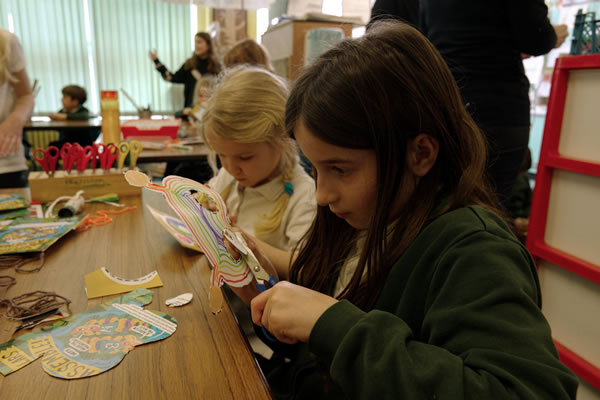 Two pupils sat at a desk creating masks
