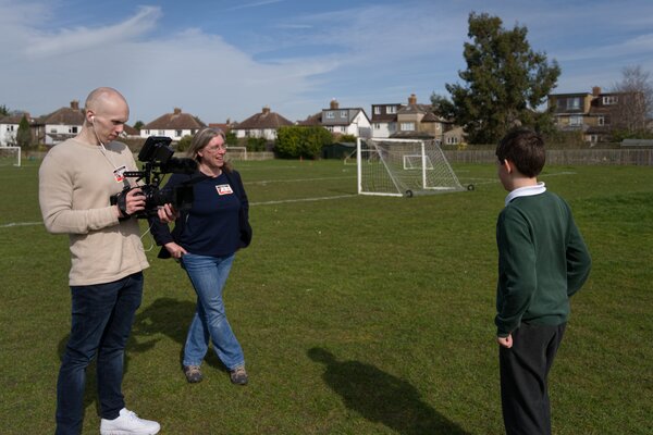 Pupil being interviewed near the football field