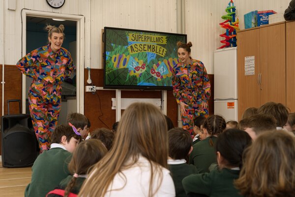 Children sat on floor watching video on tv