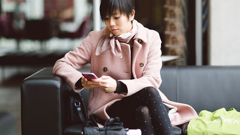 Girl sitting on sofa looking at phone