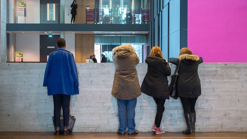 A group of students looking over the balcony