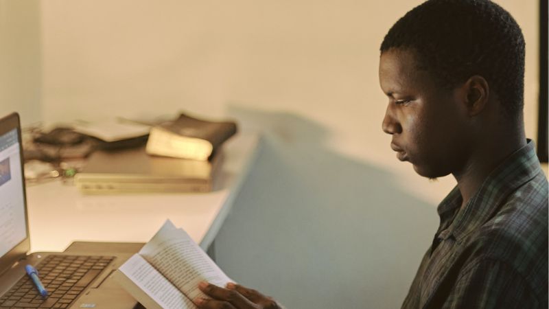 person in front of a laptop reading
