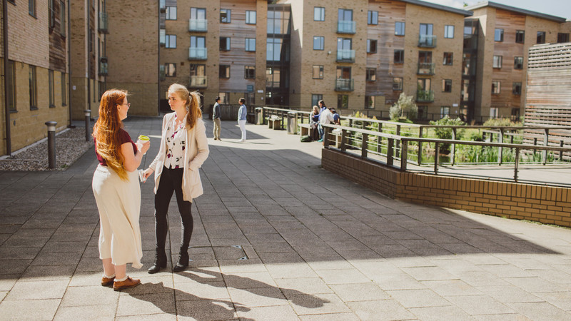 Two students stood in front of accommodation talking
