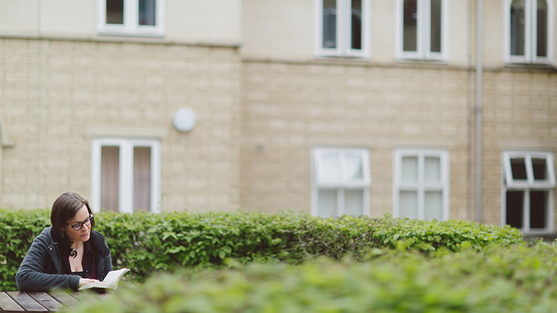 student reading outside halls